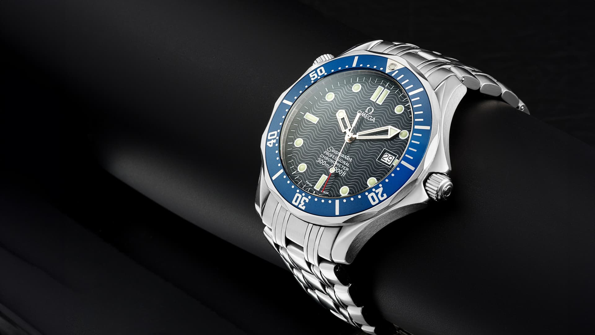 Premium Omega Seamaster luxury watch packshot on dark background. Painkiller-grade studio product photography.